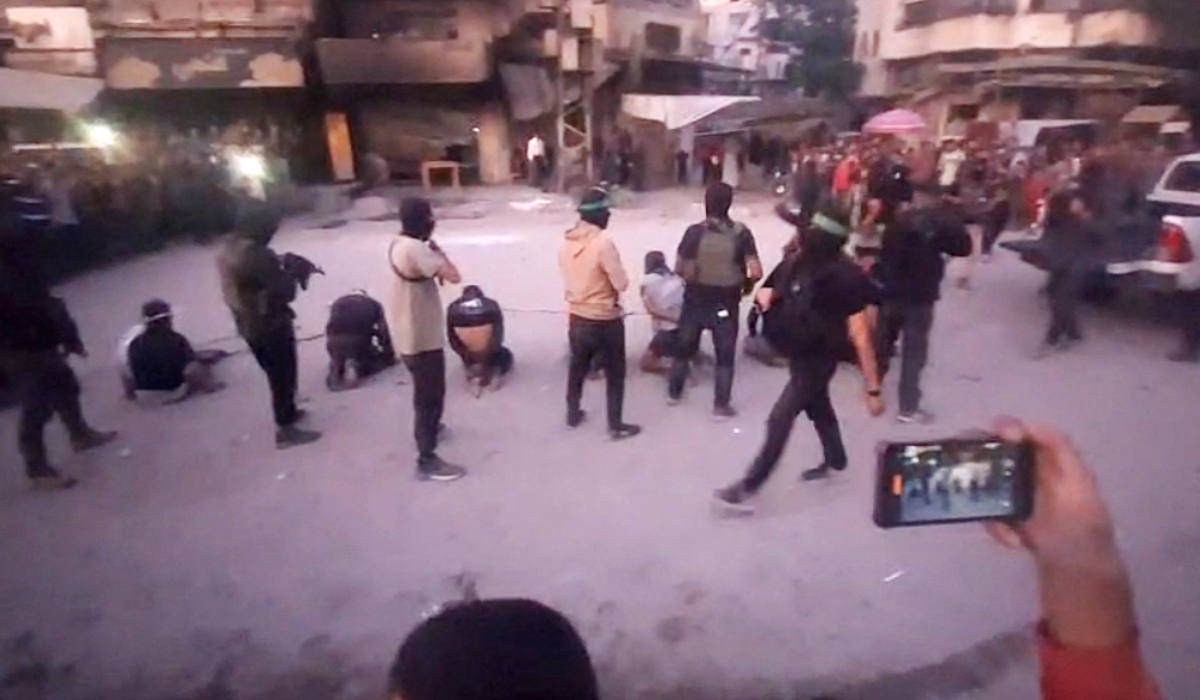 Esta imagen, tomada de un video transmitido por el canal de televisión Al-Aqsa TV Telegram, administrado por Hamás, el 13 de octubre de 2025, muestra a hombres armados de Hamás ejecutando a hombres con los ojos vendados, atados y arrodillados mientras una multitud los rodea en una calle de la ciudad de Gaza. Foto: Al-Aqsa TV / AFP