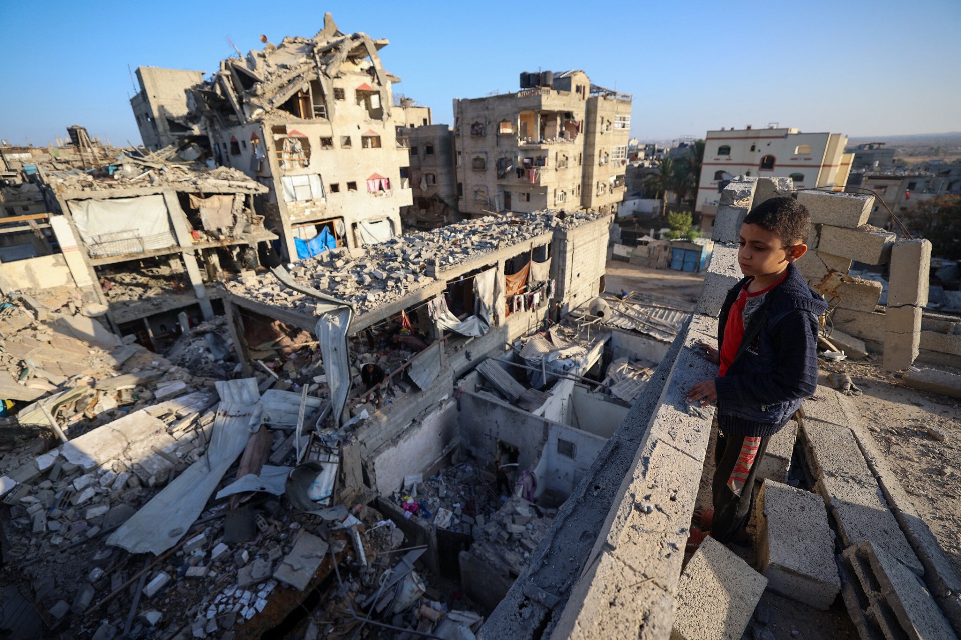 Un niño observa los escombros de los edificios destruidos en un ataque israelí en Bureij, en el centro de la Franja de Gaza, el 20 de octubre de 2025. Foto: Eyad Baba / AFP