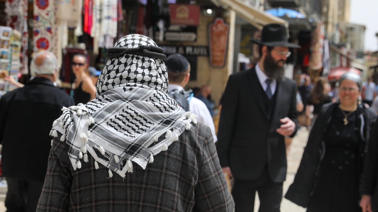 Un palestino y un judío israelí ultraortodoxo caminan por la Ciudad Vieja de Jerusalén, Israel, el 17 de abril de 2022. Foto: Marc Israel Sellem / The Jerusalem Post