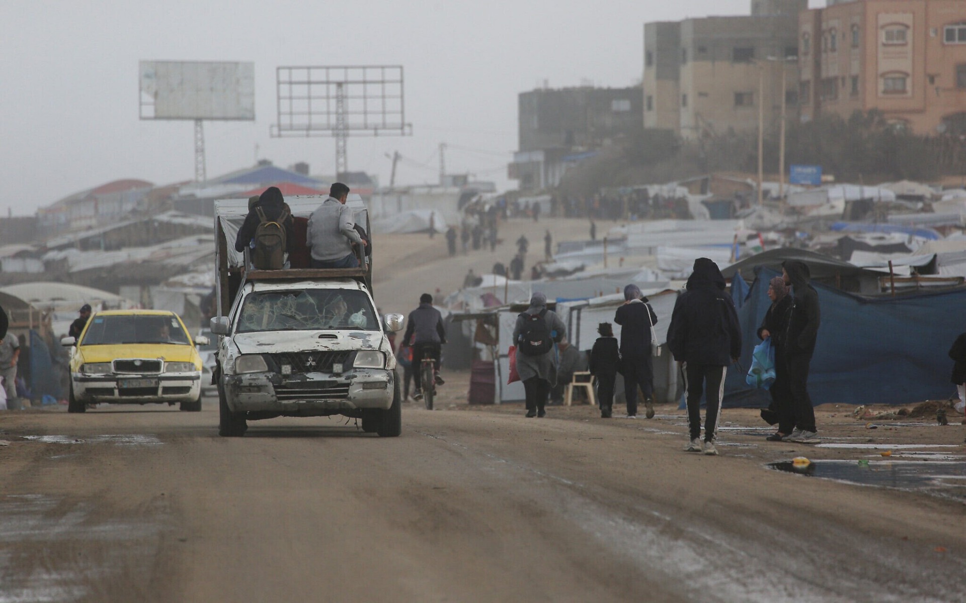 Palestinos desplazados caminan junto a un vehículo que transporta a otras familias en dirección al oeste de Deir al-Balah, en el centro de la Franja de Gaza, el 15 de noviembre de 2025. La escena refleja el continuo movimiento de civiles que buscan zonas consideradas más seguras en medio de los intensos combates y los bombardeos en la región. Foto: Bashar Taleb / AFP