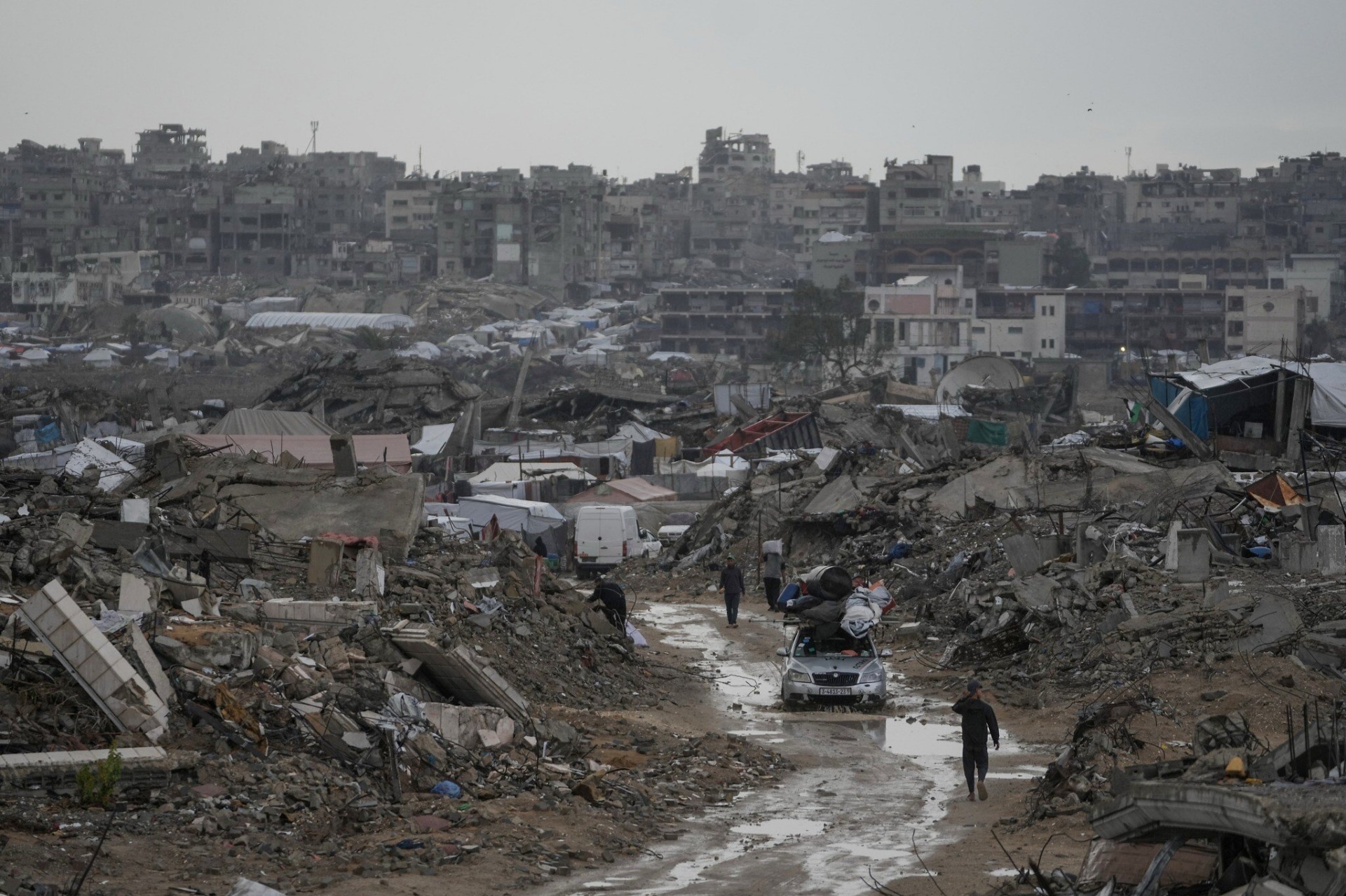 Un automóvil circula por un camino fangoso entre edificios destruidos en el barrio de Sheikh Radwan, en la ciudad de Gaza, el viernes 14 de noviembre de 2025, evidenciando la devastación causada por la guerra y las dificultades que enfrentan los residentes para desplazarse. Foto: AP/Jehad Alshrafi