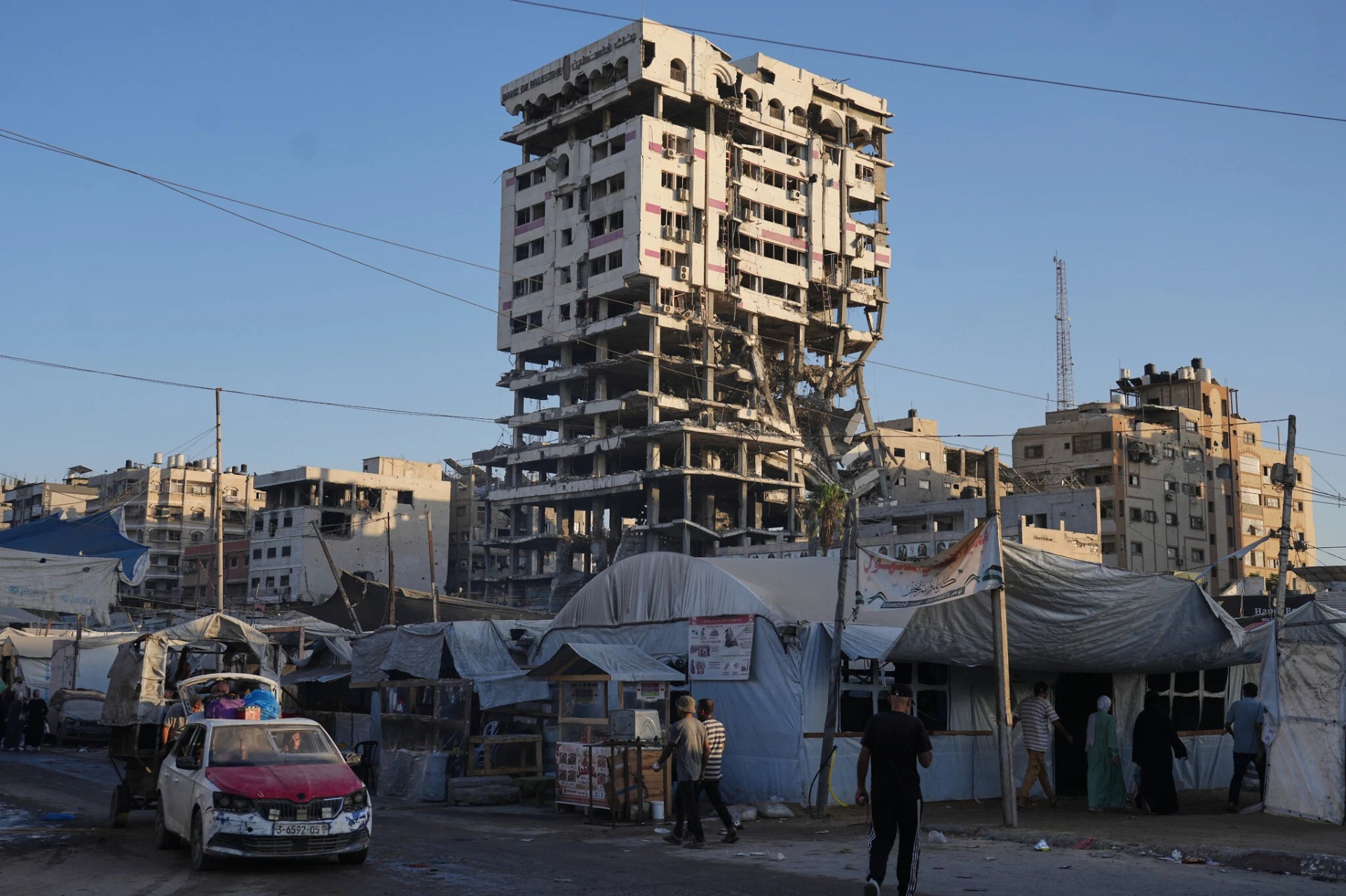 Tiendas de campaña que albergan a palestinos desplazados y un mercado rodean un edificio gravemente dañado en Gaza City, el 17 de septiembre de 2026. Foto: AP / Jehad Alshrafi