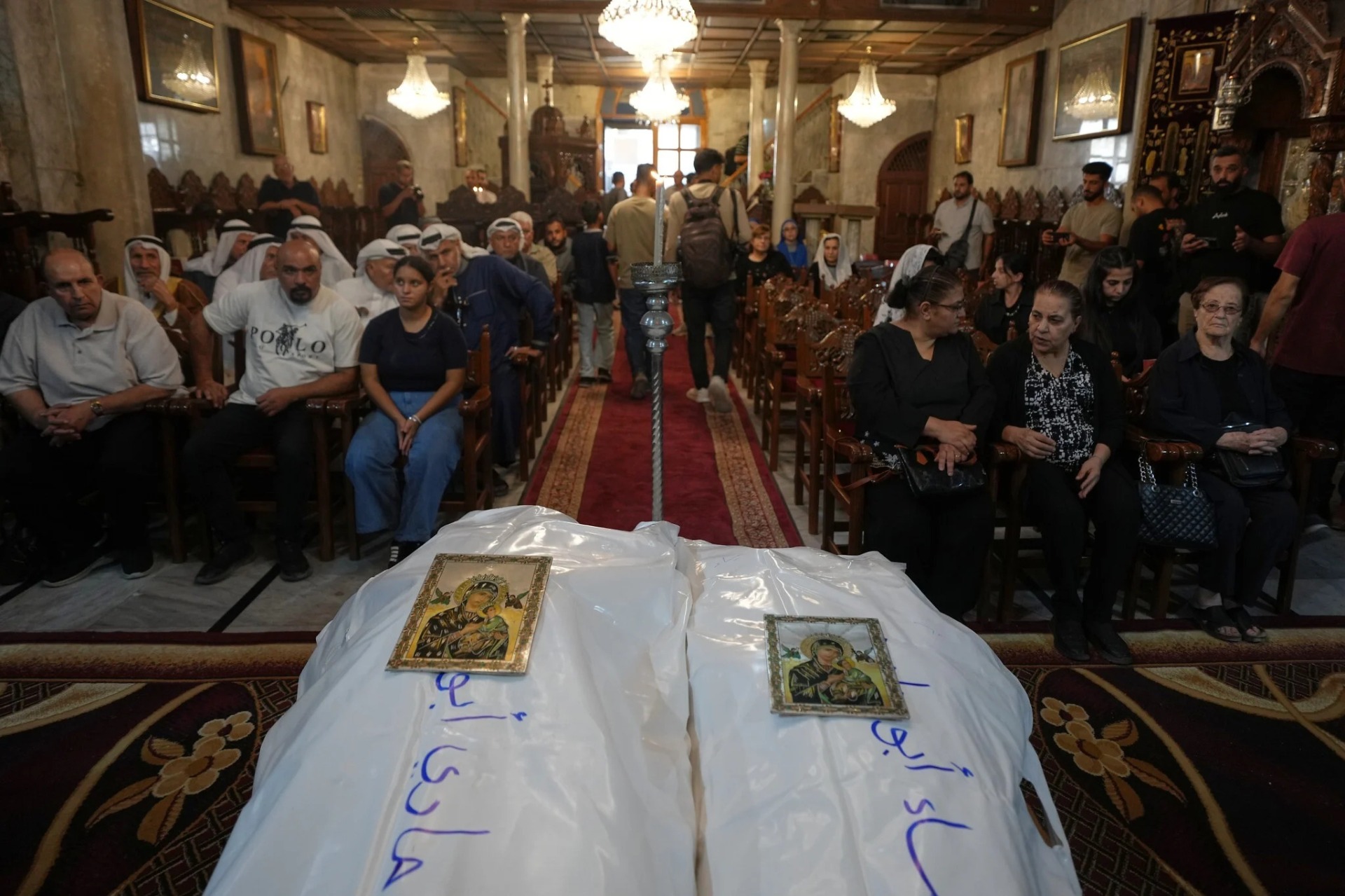 Dolientes participan del funeral de las palestinas Maisaa Abu Dawood y su hija Mary, quienes murieron durante un ataque aéreo israelí ocurrido en la madrugada, en la Iglesia de San Porfirio, en Ciudad de Gaza, el 3 de octubre de 2026. Fotografía: Jehad Alshrafi / AP