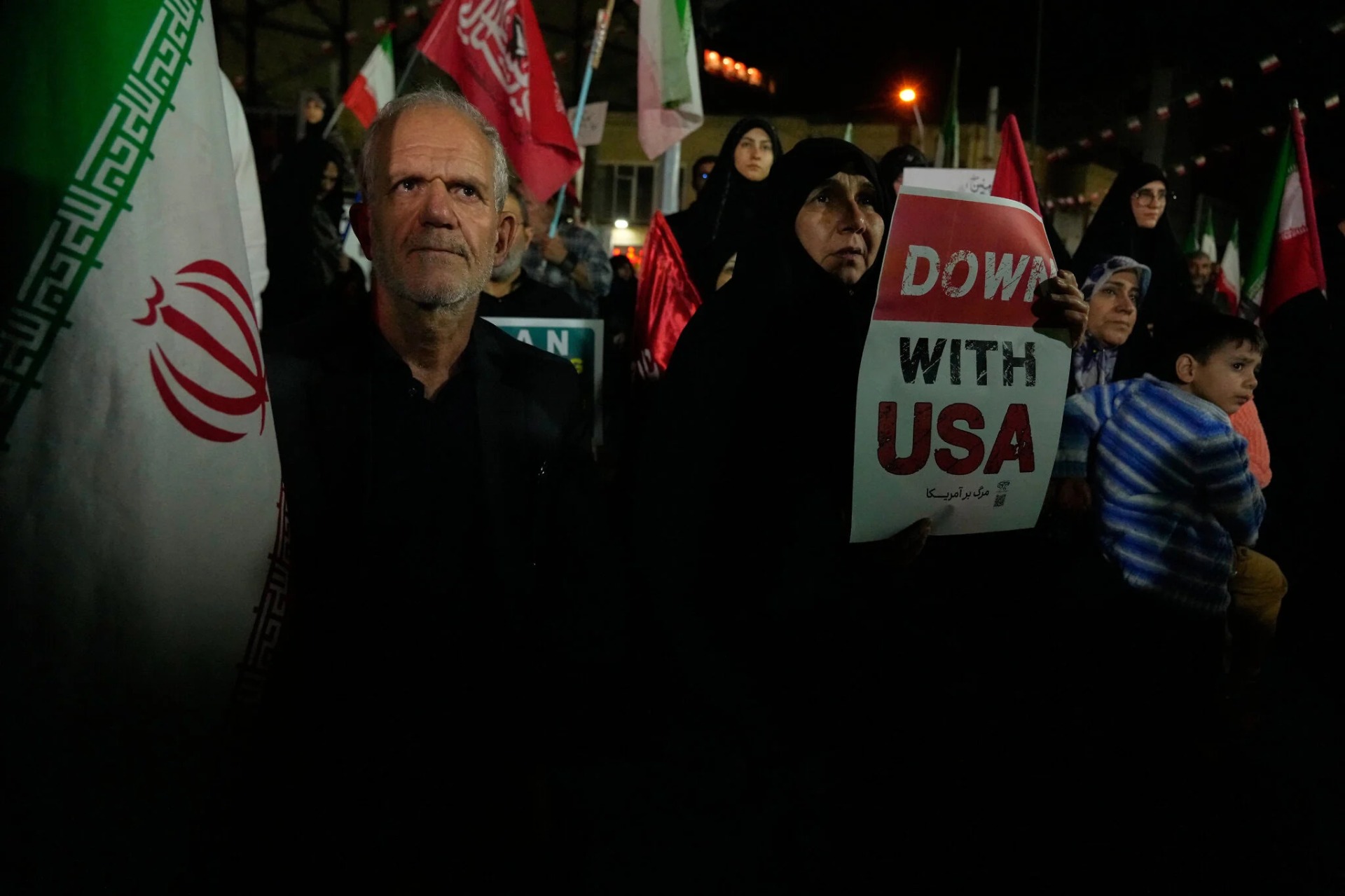 Un manifestante sostiene un cartel contra Estados Unidos mientras otro levanta una bandera iraní durante una concentración progubernamental en Teherán, Irán, el 27 de octubre de 2026. Fotografía: AP / Vahid Salemi