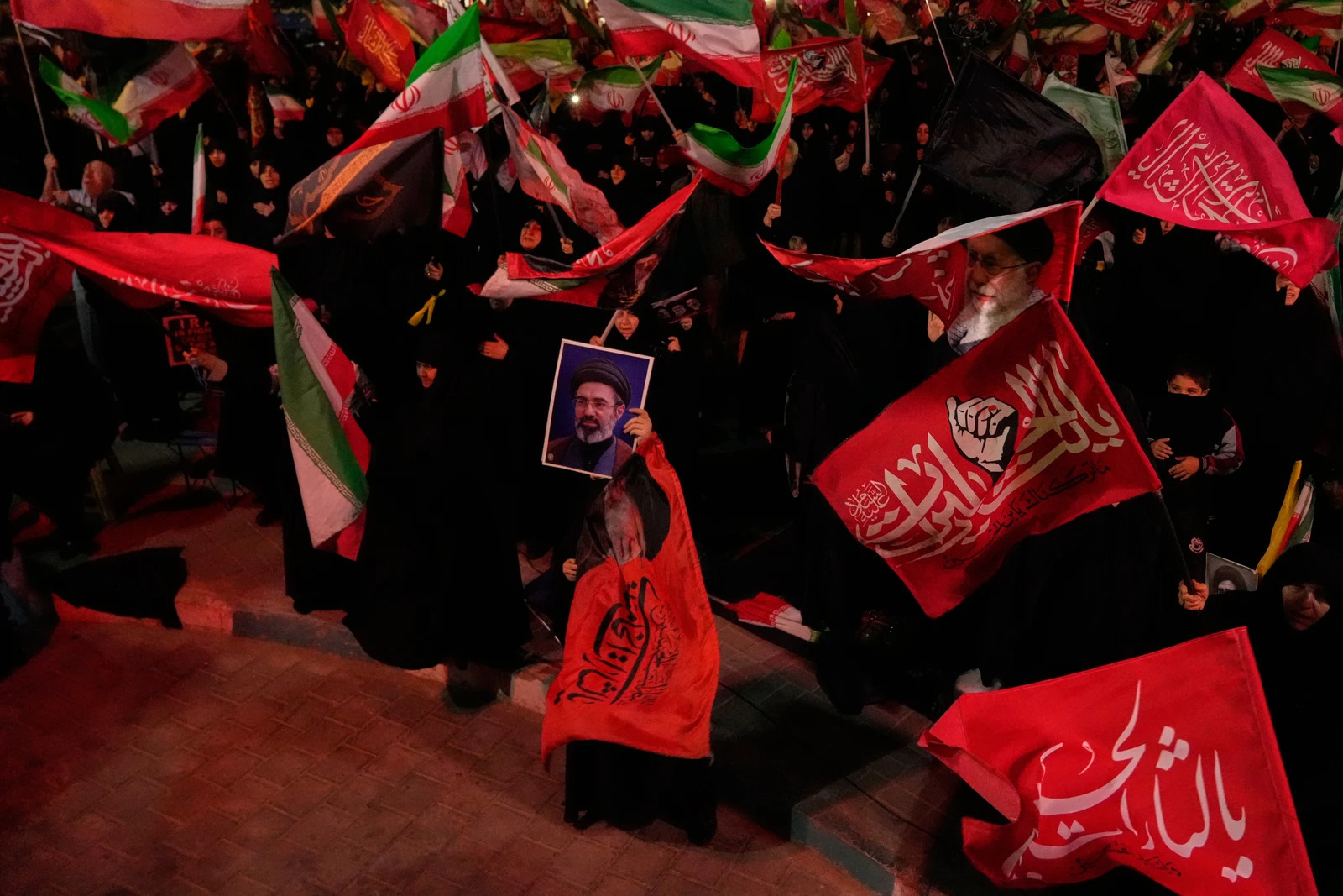 Manifestantes ondean banderas iraníes mientras uno de ellos sostiene un retrato del líder supremo de Irán, el ayatolá Mojtaba Jamenei, durante una concentración progubernamental en Teherán, Irán, el martes 27 de octubre de 2026. Fotografía: AP / Vahid Salemi